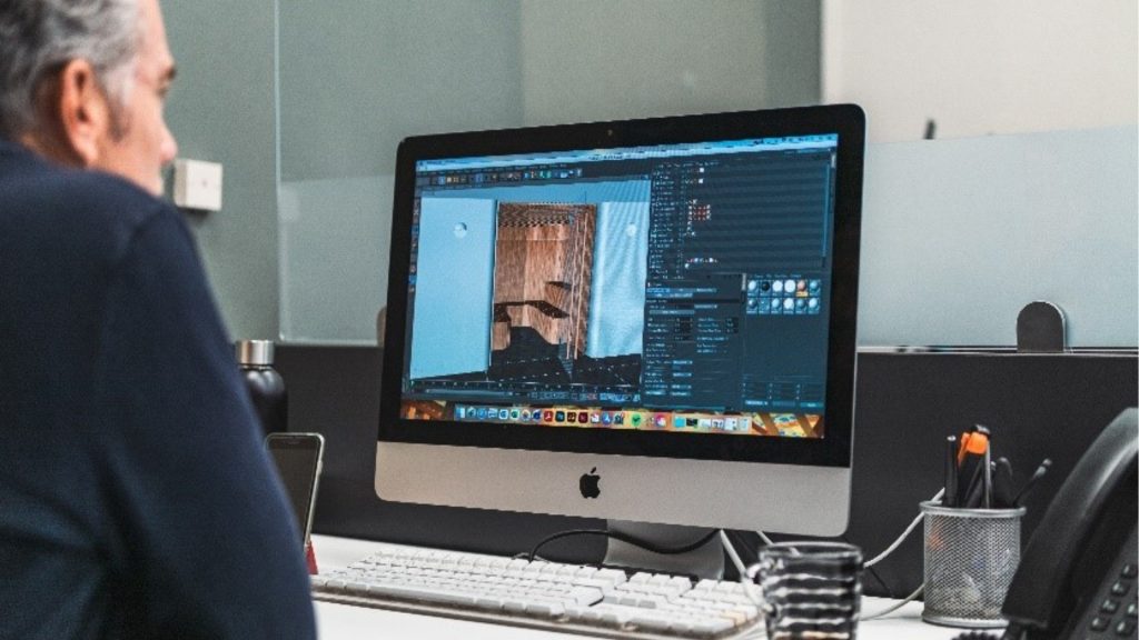 A Ripple designer working on a detailed 3D interior render using modelling software on a desktop computer.