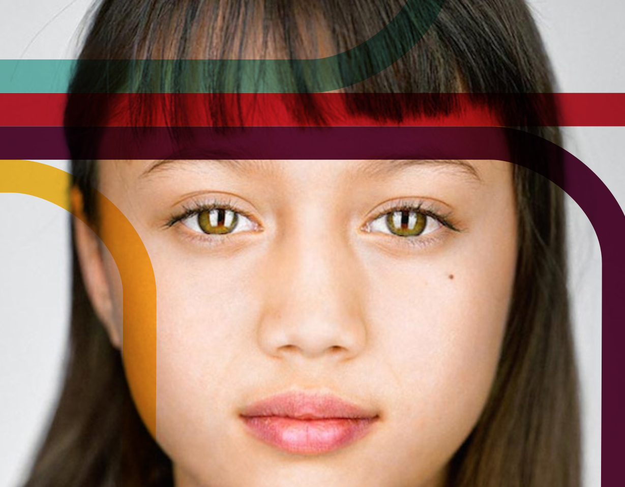 Close-up portrait of a young woman with light green eyes, straight dark hair with bangs, and natural lips.