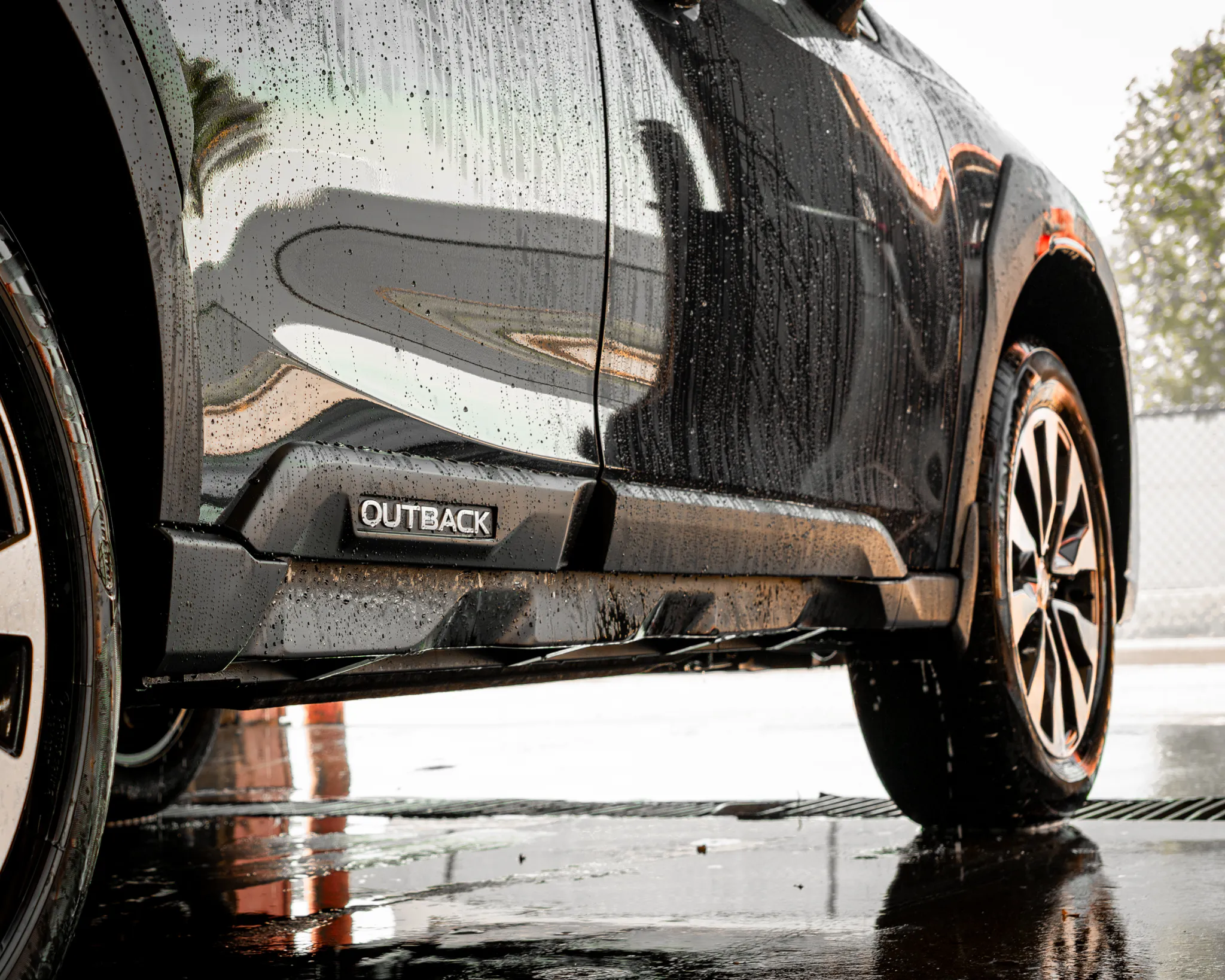 Photo of a freshly washed Subaru Outback SUV dripping water right before the drying process of a full-service detail by Madison Auto Trim, LLC