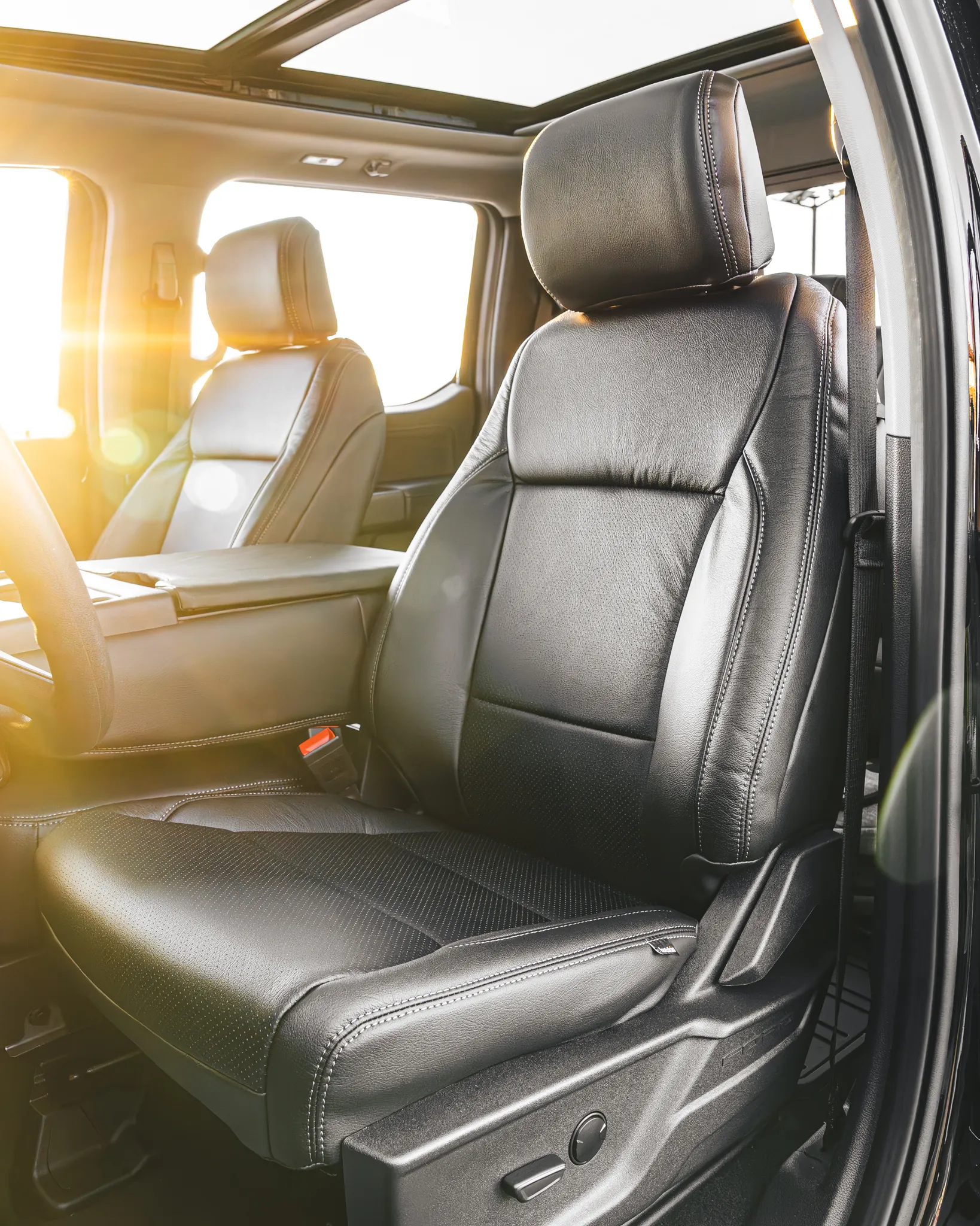 Photo of sun flares shining through car window on a single color custom Katzkin leather seat fitting from Madison Auto Trim, LLC.