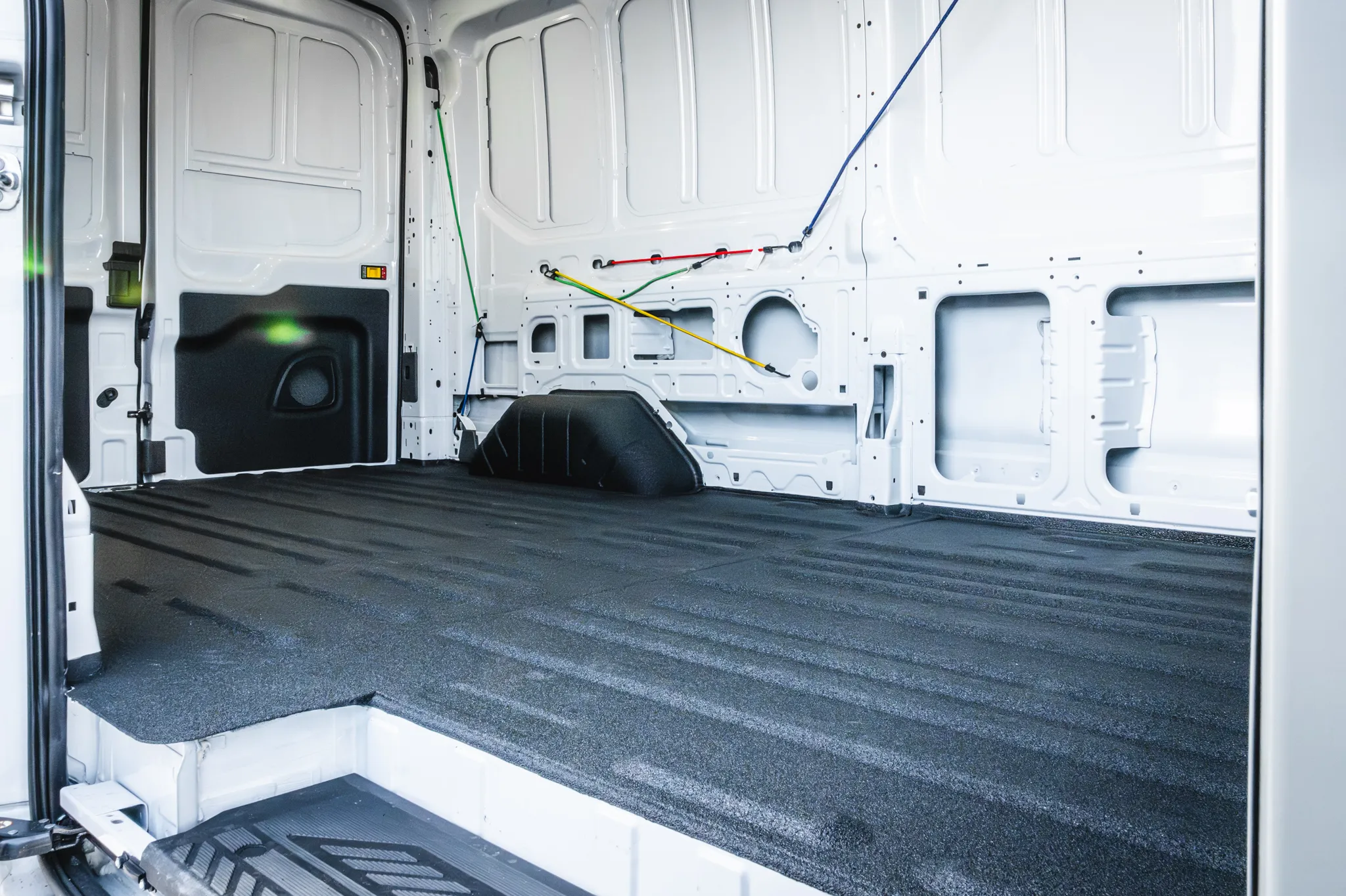 Photo of a work van interior with freshly applied spray-in bedliner by Madison Auto Trim, Wisconsin. Durable protective coating, spray-in truck bed liner, anti-scratch and corrosion-resistant vehicle protection.