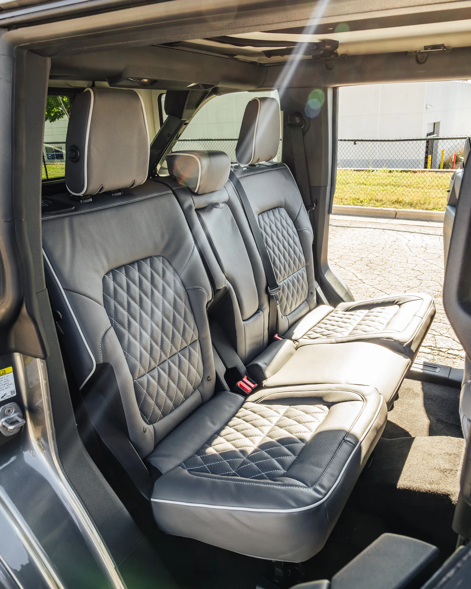 Three seats in a single row of grey and white custom Katzkin leather rear seats professionally installed by Madison Auto Trim, Wisconsin.