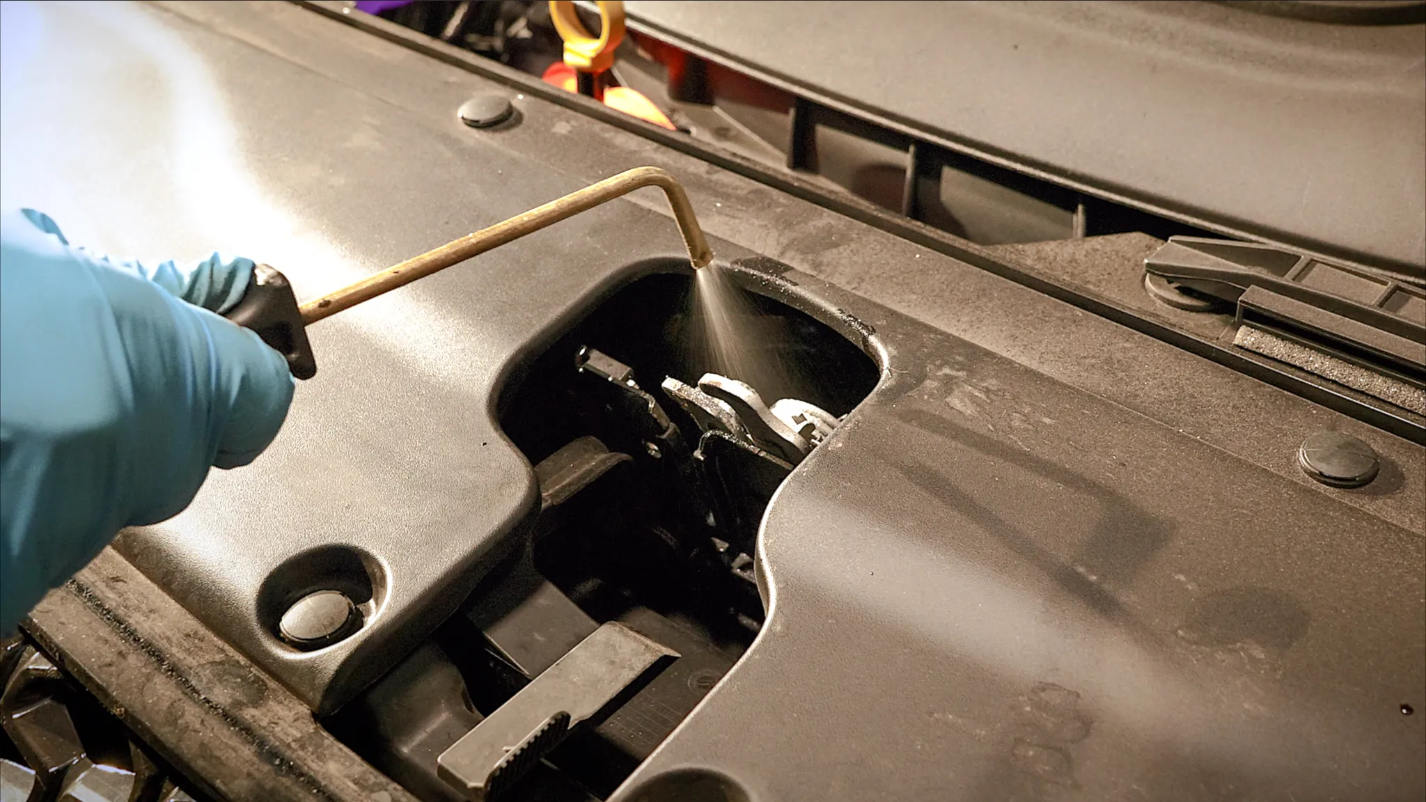 Sedan hatch and tailgate being treated with professional rustproofing spray by Madison Auto Trim, Wisconsin. Vehicle corrosion protection, anti-rust undercoating, and preventive rustproof services.