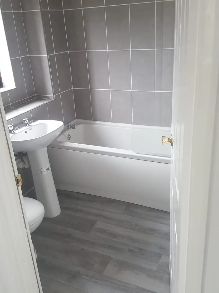 Grey wood-effect vinyl flooring in a family bathroom