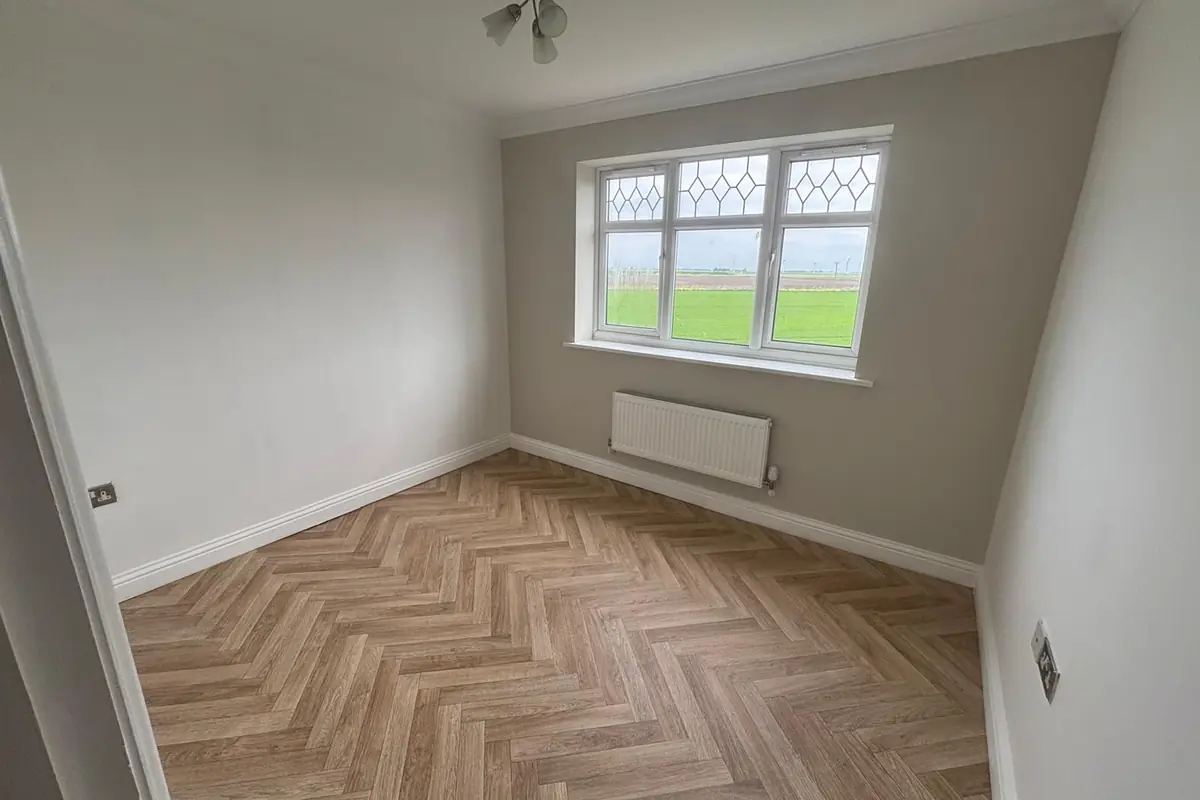 Herringbone luxury vinyl tile flooring in a bright room