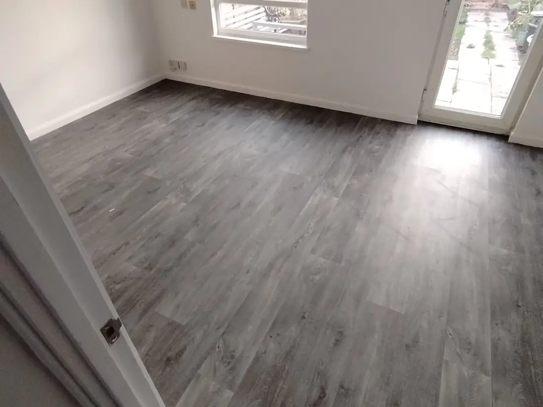 Grey wood-effect vinyl flooring in a kitchen-diner opening onto the garden