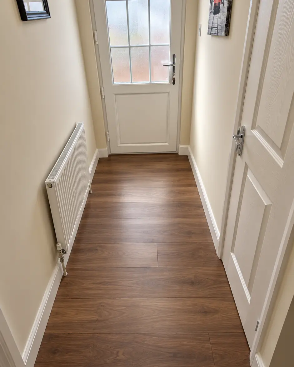 Walnut-effect laminate flooring fitted along a hallway to the back door