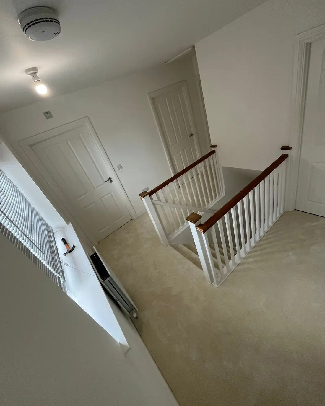 Cream carpet fitted across a landing and down the stairs