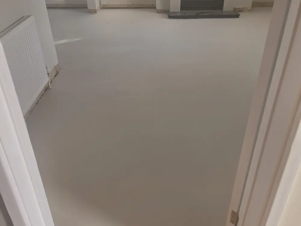 A living room floor freshly screeded and levelled, ready for engineered wood