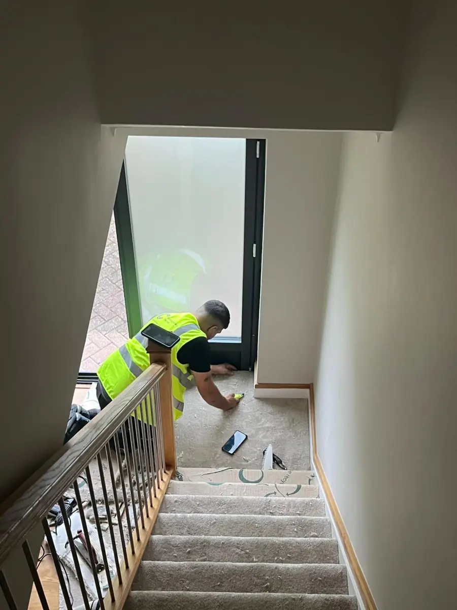 A fitter fitting carpet to a staircase