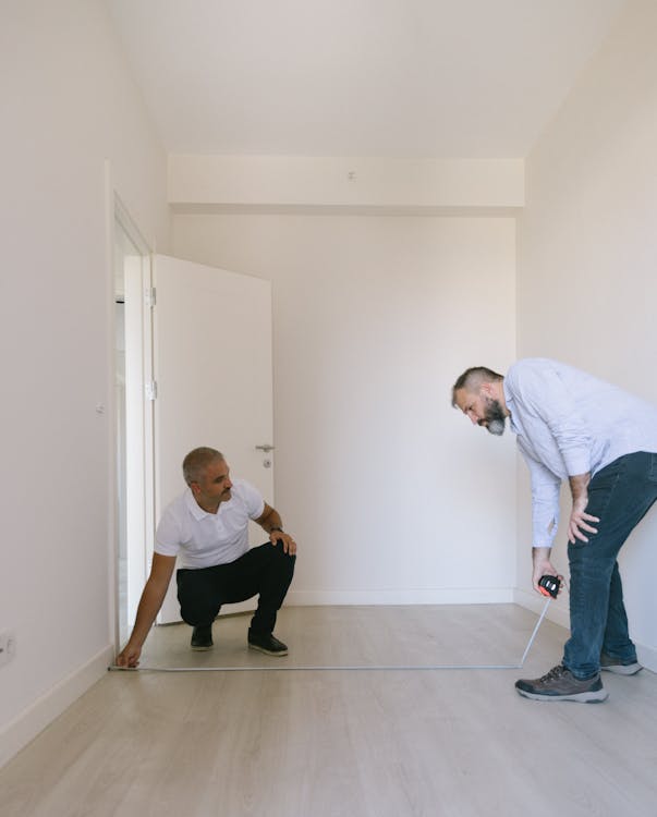 Carpet fitters measuring a room floor for professional carpet fitting in Peterborough, Cambridgeshire — Cambridgeshire Carpets Ltd