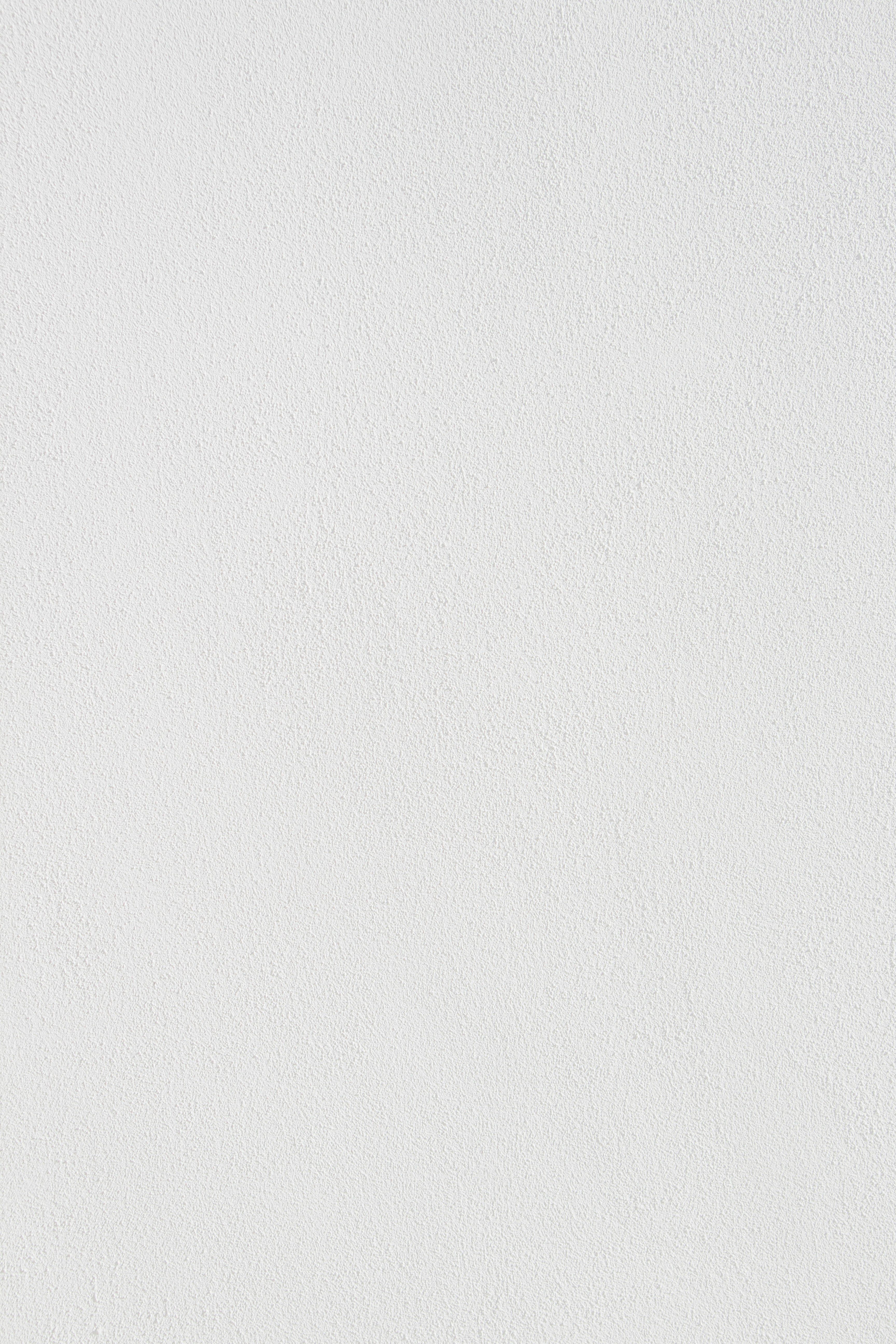 White stucco textured wall with a rough surface pattern.