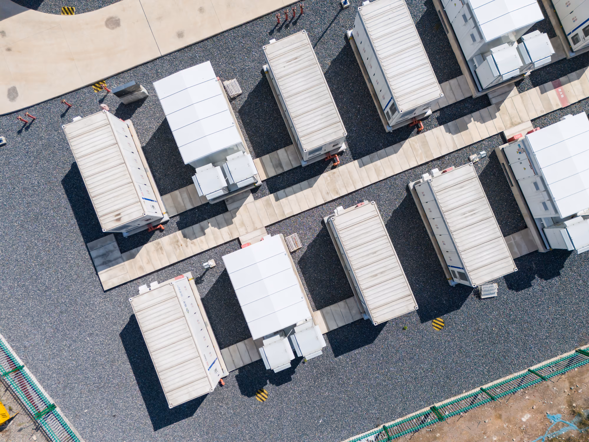 Aerial view of rows of white industrial containers or trailers on gravel with paved walkways.