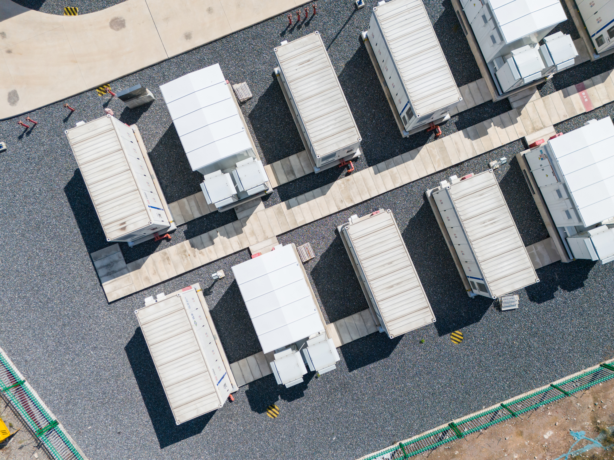 Aerial view of rows of white industrial containers or trailers on gravel with paved walkways.