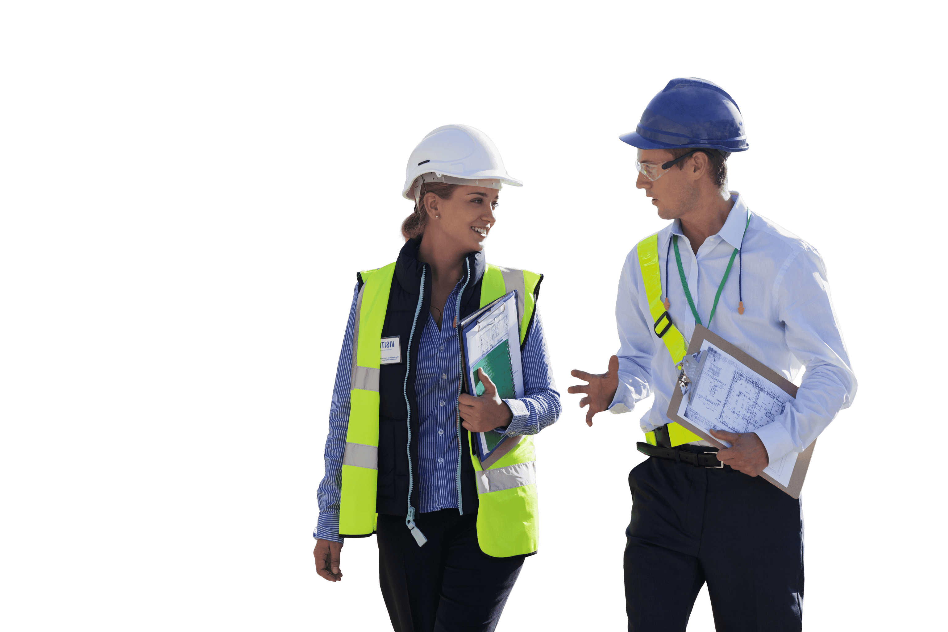 Two construction professionals wearing hard hats and safety vests, walking and discussing plans.