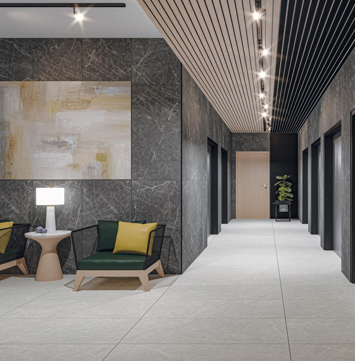 Modern lobby corridor with dark marble walls, cream tile floor, multiple elevator doors, a wooden door at the end, and seating area with armchairs, a side table, and lamp.