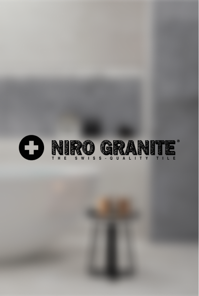 Niro Granite logo with a black cross icon and tagline 'The Swiss-Quality Tile' on a blurred gray background.