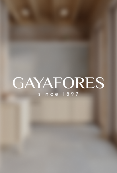 Blurred modern bathroom interior with wooden ceiling and cabinetry, with GAYAFORES logo and 'since 1897' text centered.