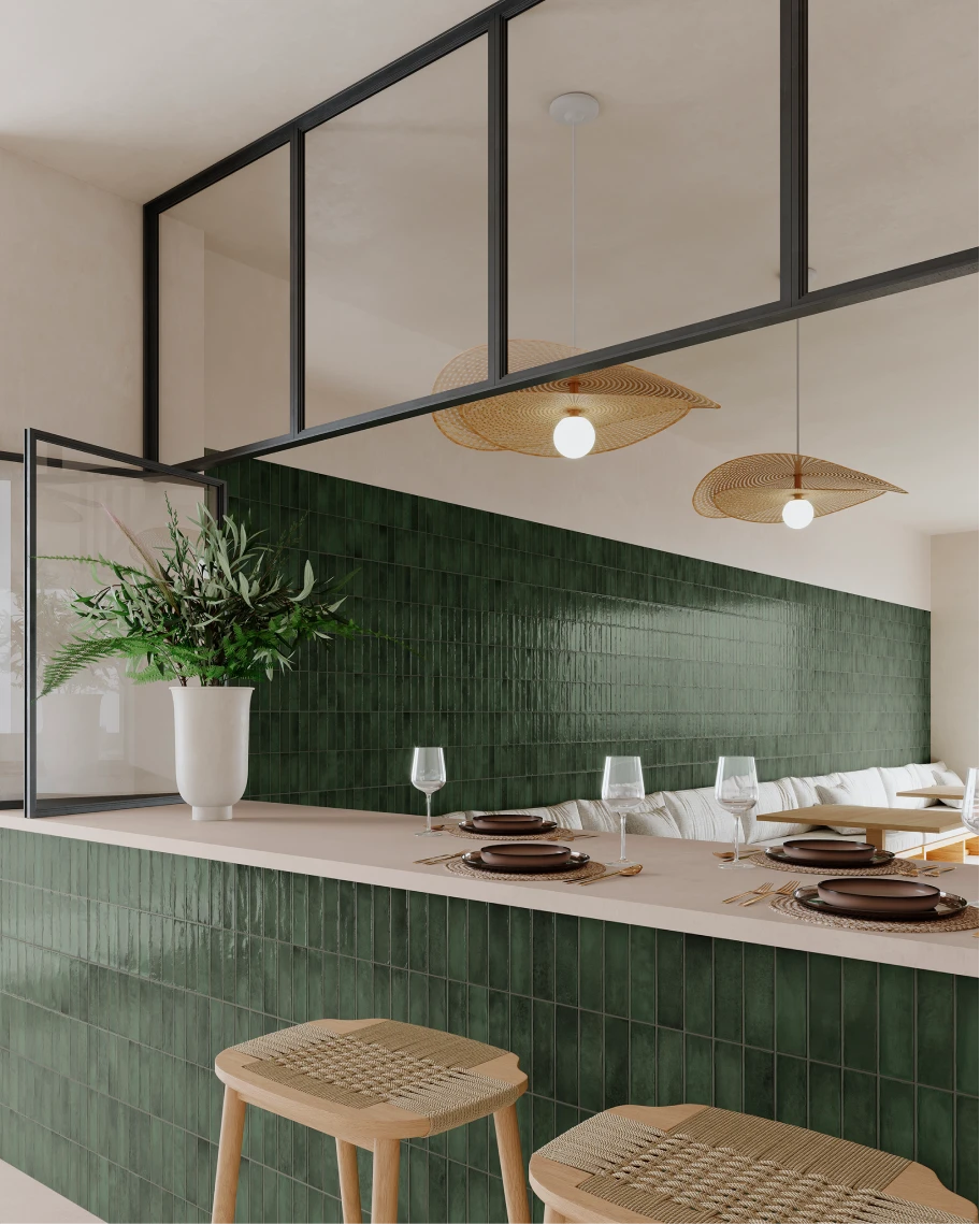 Modern kitchen with green tiled bar, woven wooden stools, white vase with green plants, and hanging rattan pendant lights.