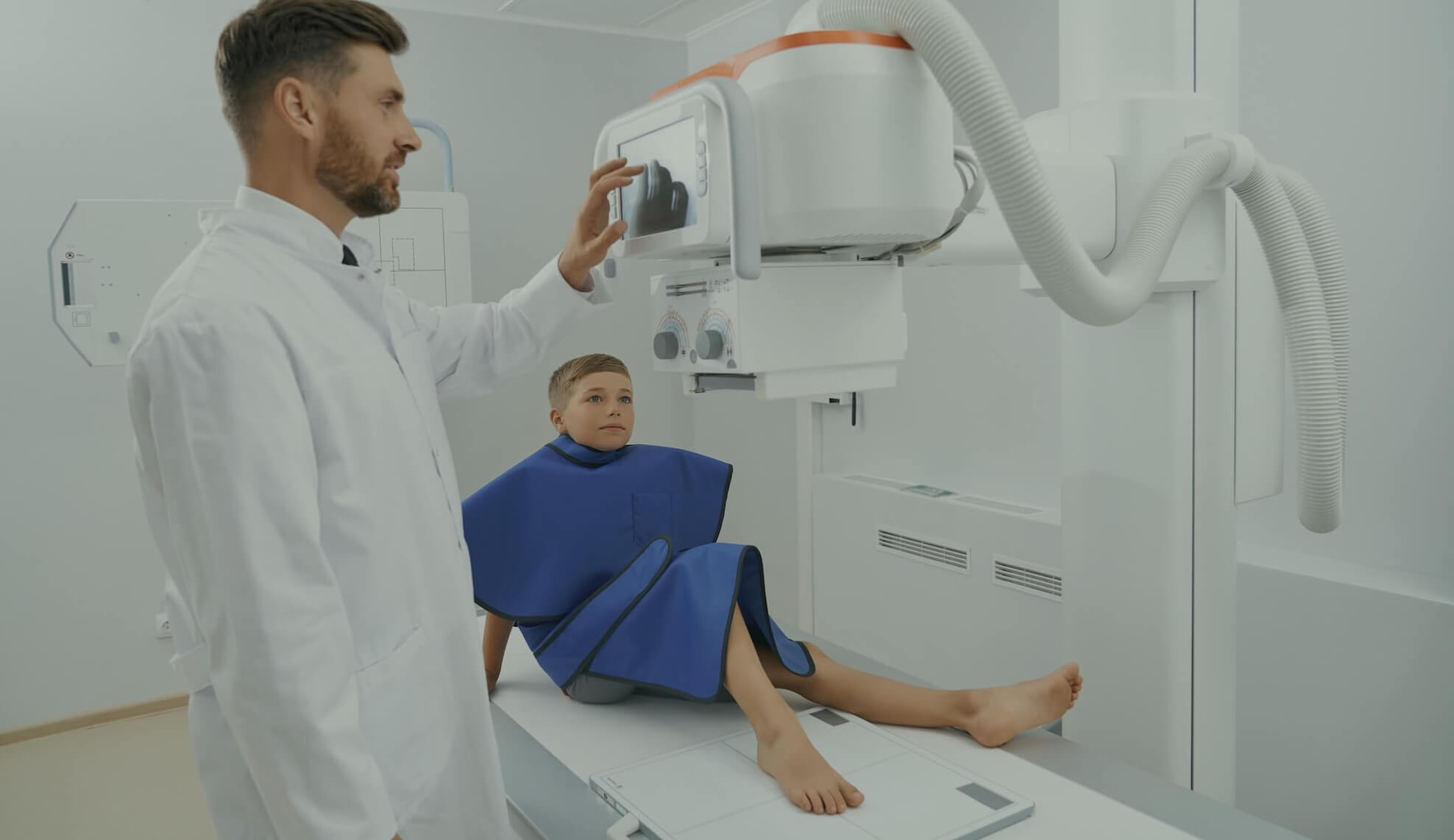 "Medisch medewerker positioneert een patiënt voor een röntgenopname met een moderne röntgeninstallatie."