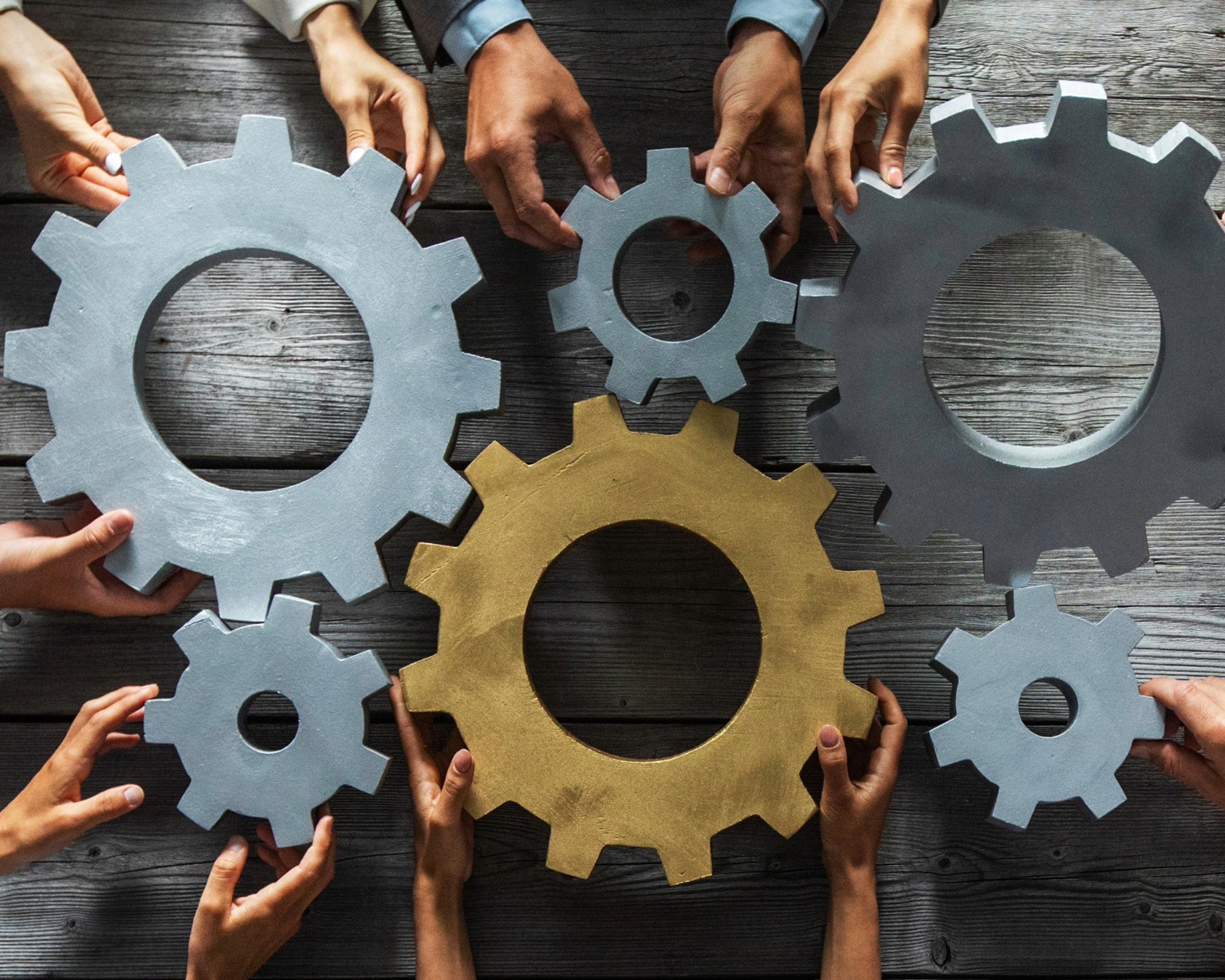 hands holding up and supporting gears