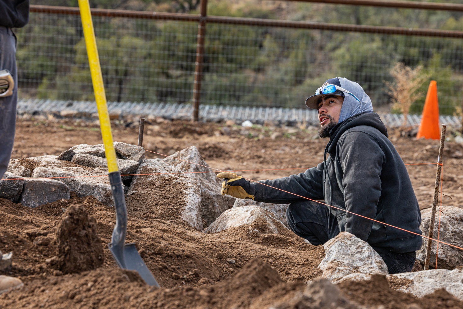 Crew member setting stone by hand on site