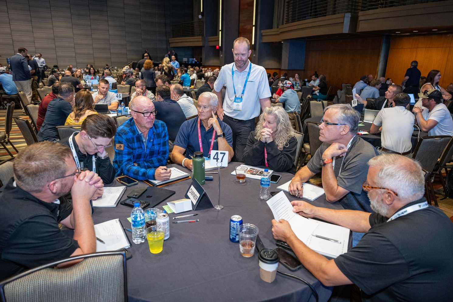 Owners and managers working at round tables during an Intensive session