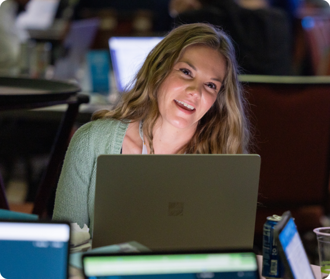 Attendee smiling at her laptop