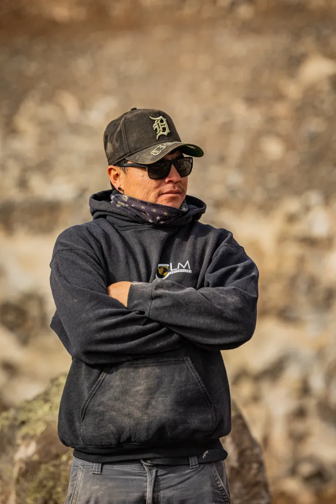 A CLM crew member, arms crossed, on the job