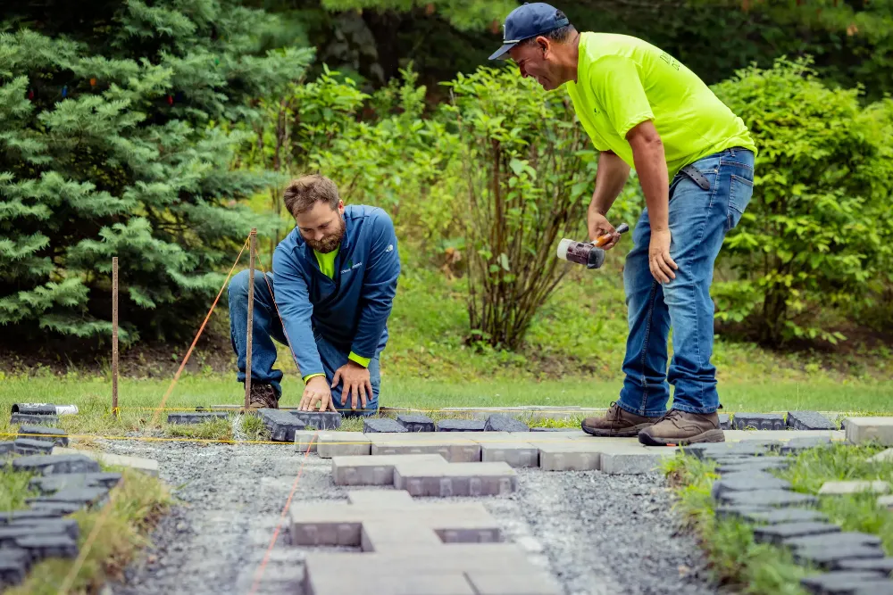 Two Downer Brothers crew setting pavers together