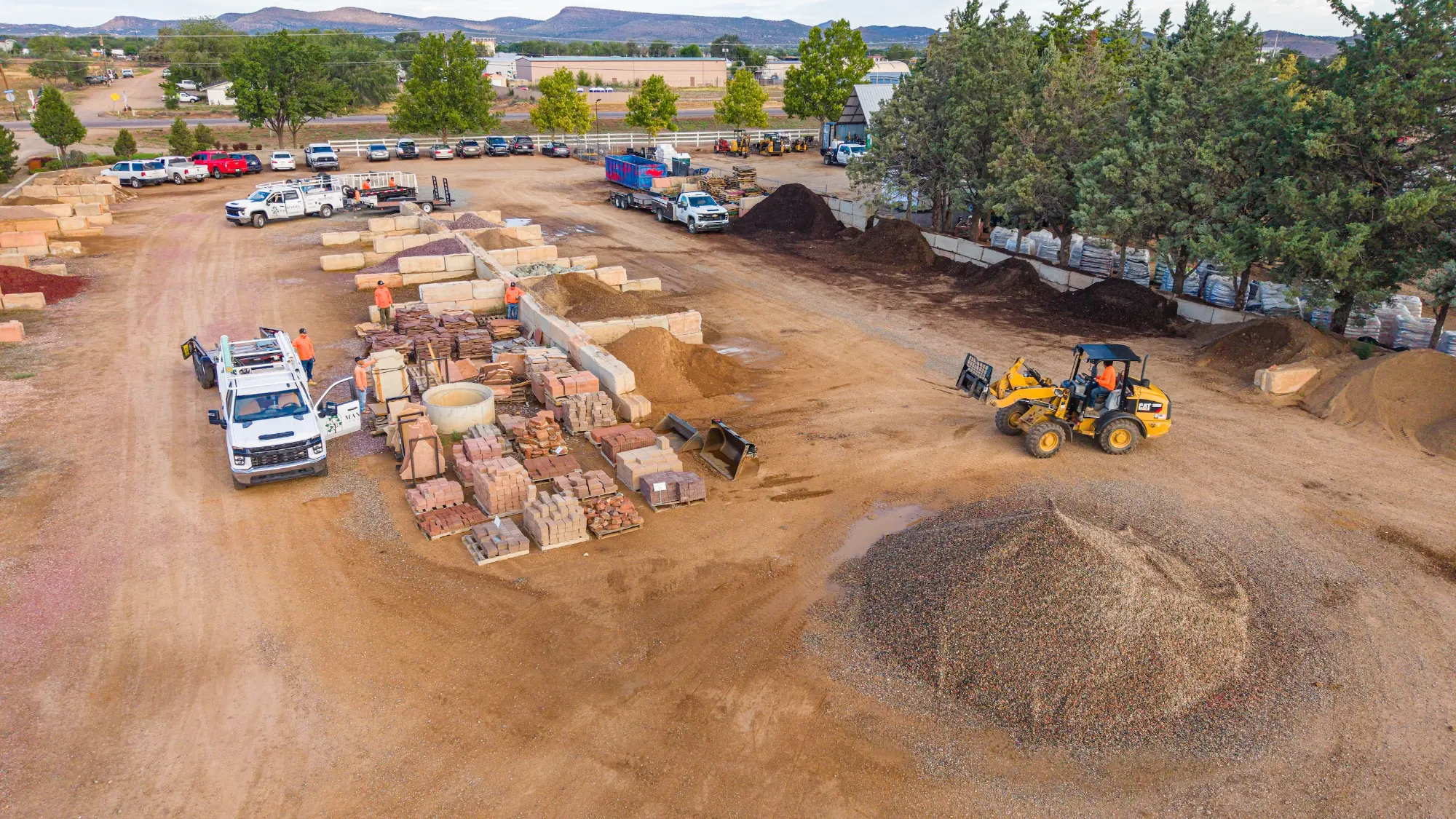 Aerial view of the Manzanita Landscaping yard, trucks, material piles and a loader