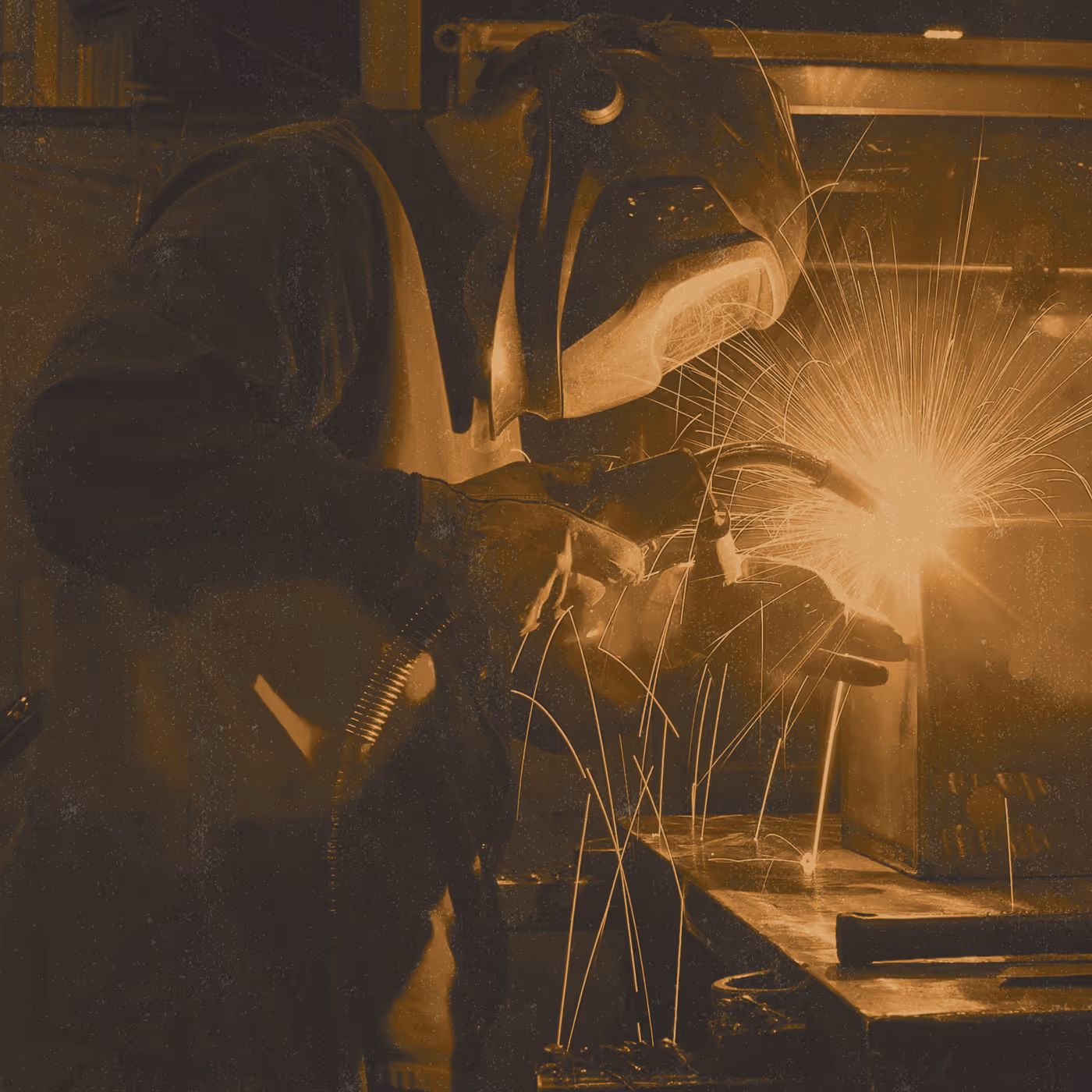 A man welding something in a duotone effect.