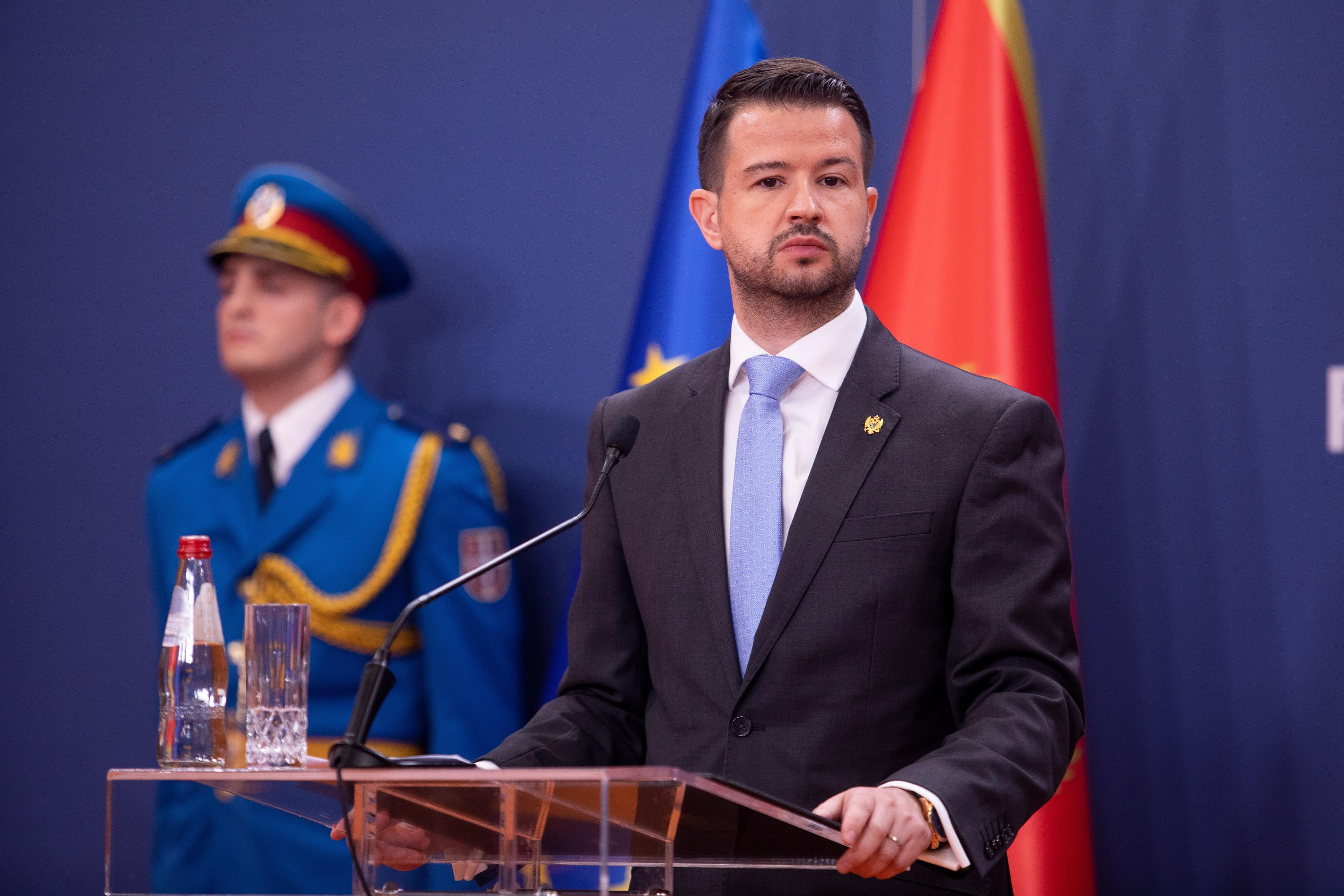 President Milatović of Montenegro speaking at a podium with EU and Montenegrin flags in the background