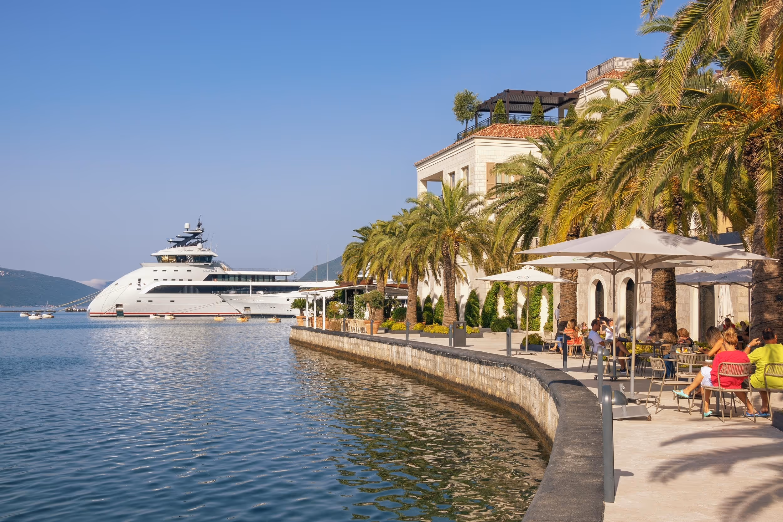 Porto Montenegro waterfront with superyacht, palm trees and mountains, Tivat Bay