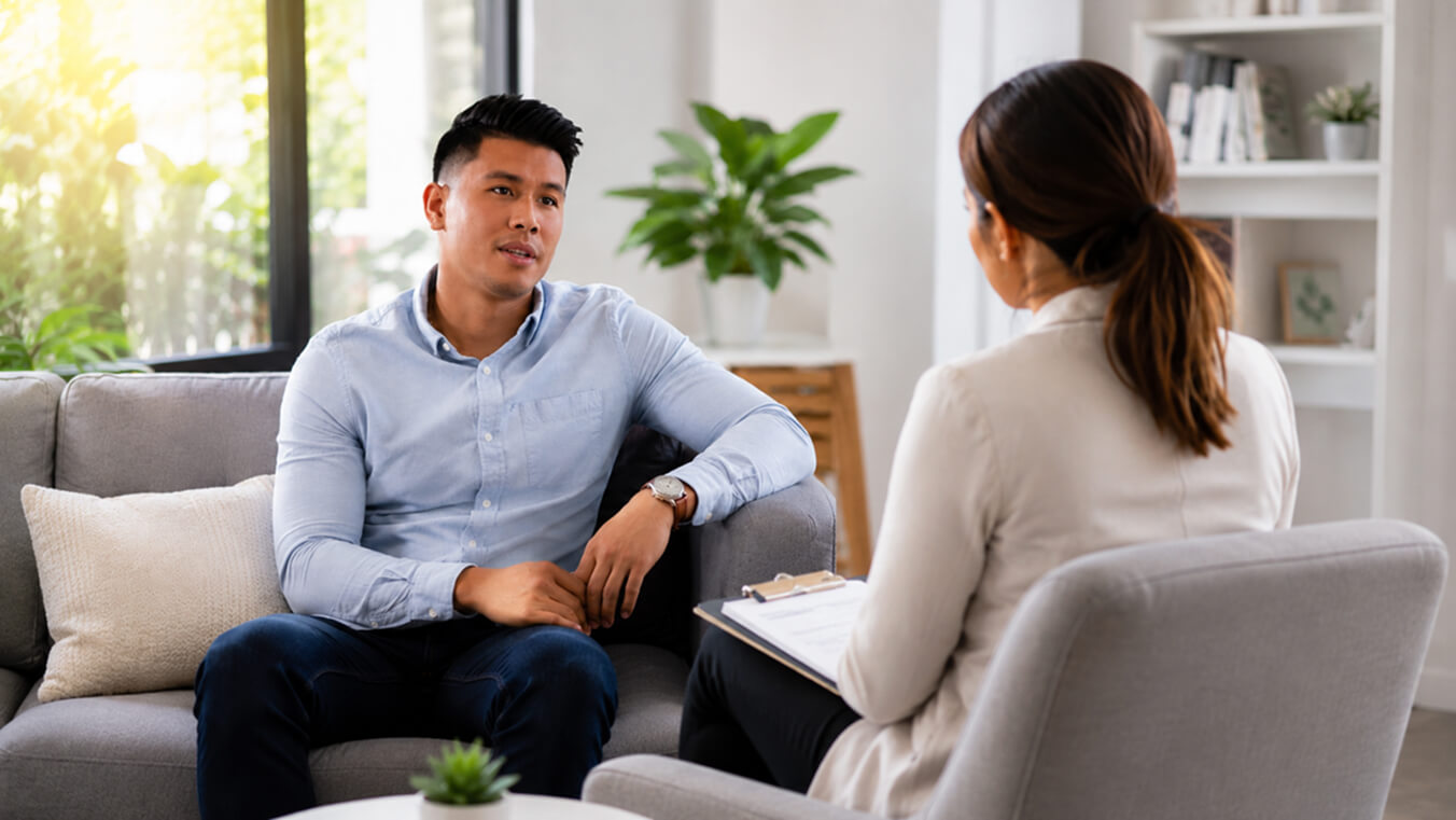 Young veteran speaking with a counsellor in a bright, modern office about DVA alcohol use disorder treatment and support.