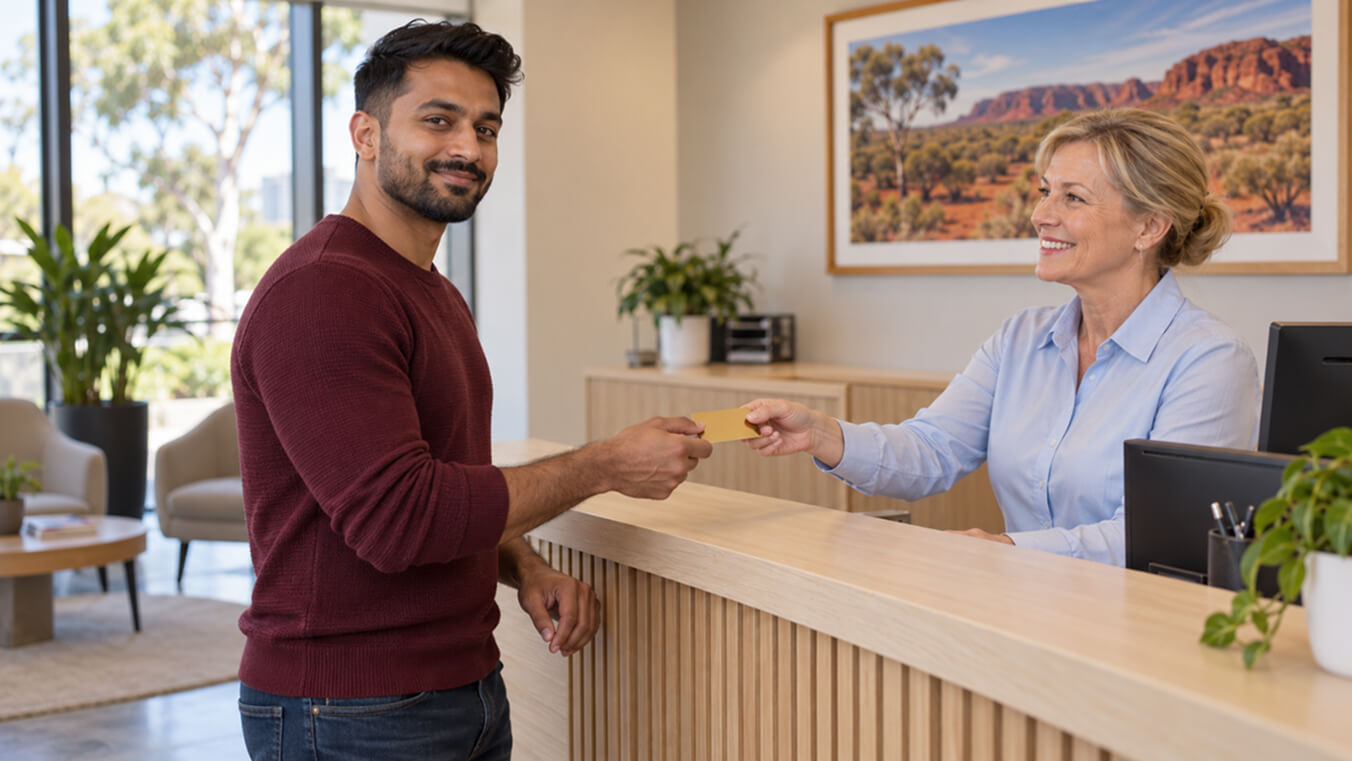 Young Australian veteran receiving a DVA Gold Card from a representative at a professional office reception desk.