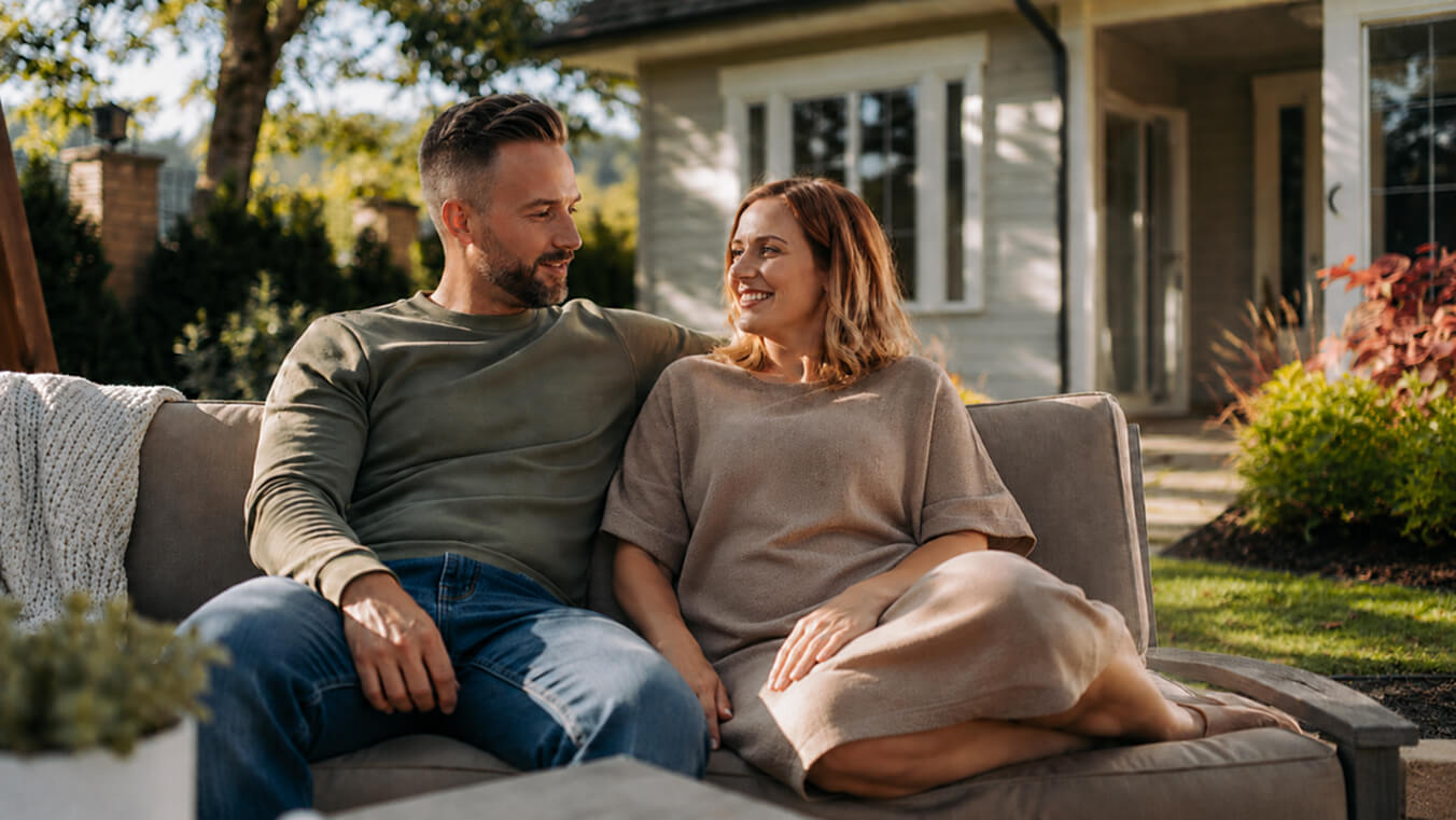 Young Australian veteran relaxing in the backyard with his partner, showing respite support under Veterans Home Care.