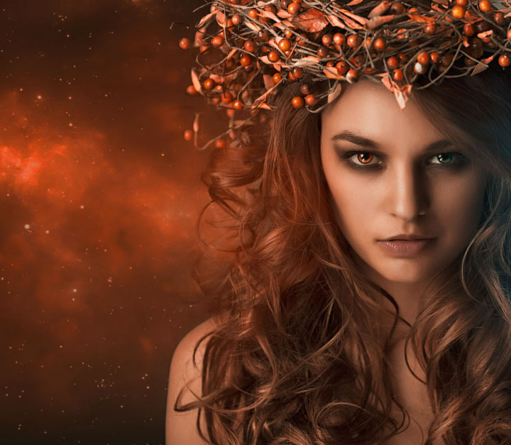 Ethereal woman wearing a crown of berries with one red eye and one green eye by Renee Robyn