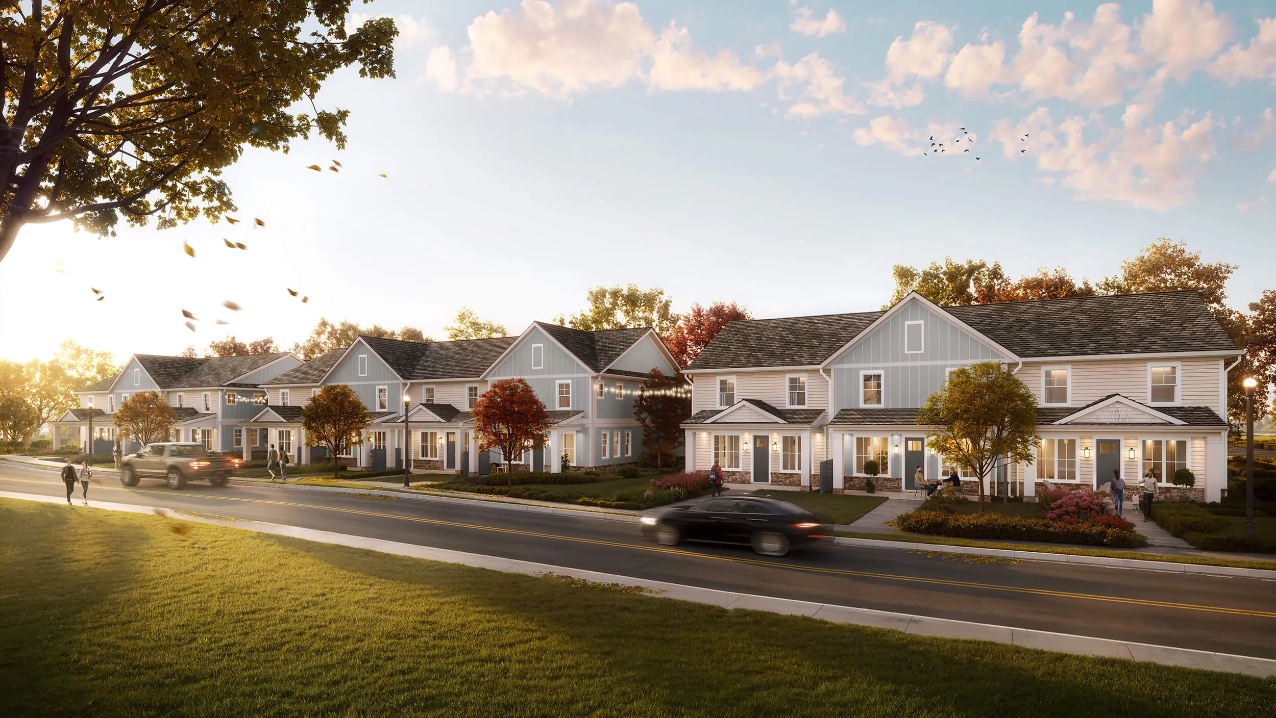 Row of modern two-story townhouses with people walking and cars driving on street at sunset.