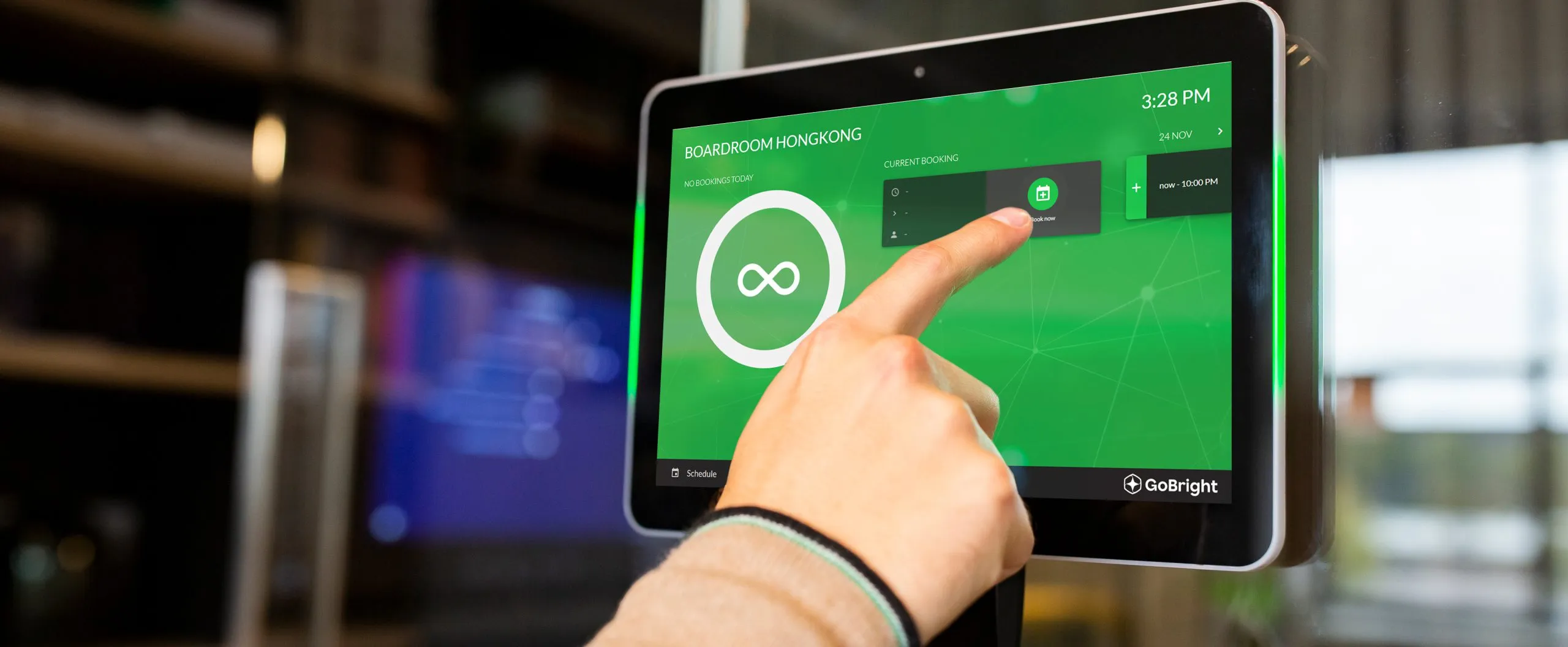 Een hand die op een touchscreen interface tikt om een bureau te reserveren.