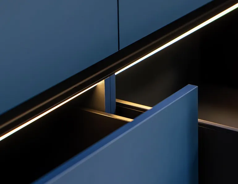 Detailaufnahme einer blauen Schublade mit integrierter LED-Beleuchtung unter der oberen Kante.