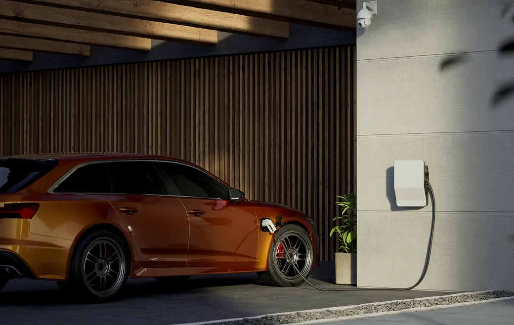 Orangenes Elektroauto, das in einer Garage an einer Wandladestation aufgeladen wird.