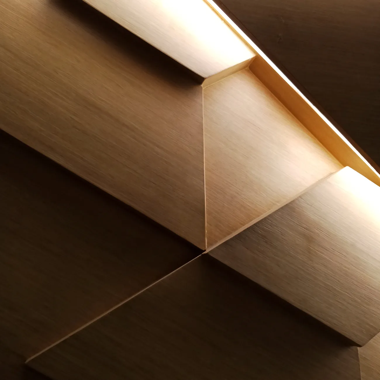 Nahaufnahme eines modernen Decken- oder Wandpaneels aus hellem Holz mit integrierter Beleuchtung.