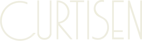 Beige stoff med et delikat, lysegult abstrakt mønster.