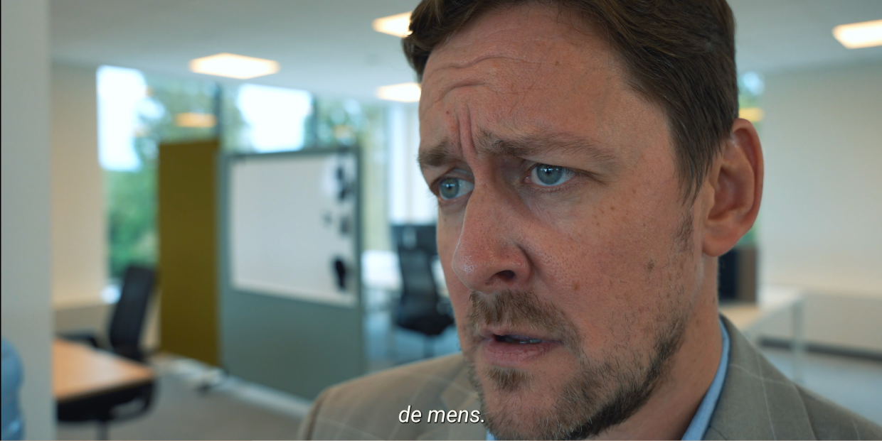 Zoomed-in still of the Arxus HR video showing the main actor's face up close, sighing.