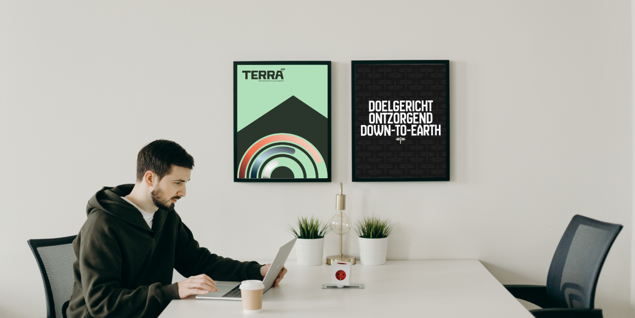 Photo taken in the office of a terra employee in a meeting room with terra graphics displayed on a screen against the wall.