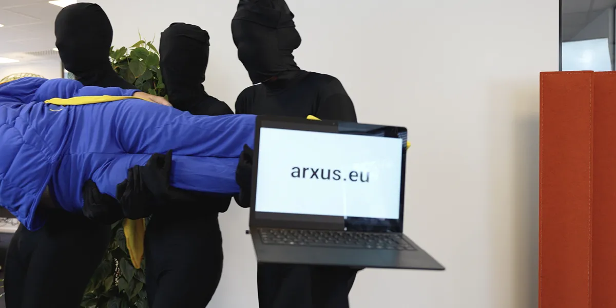 Zoomed-in still of the Arxus HR video showing the main actor being carries and a laptop with arxusbe on screen.