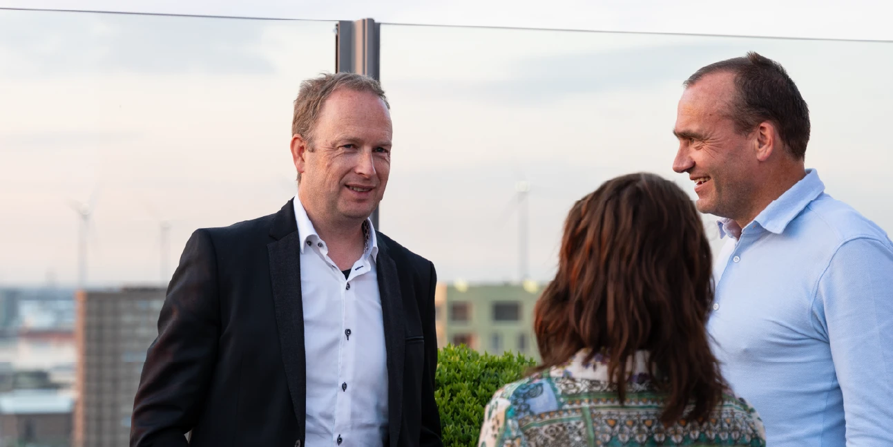 Photo taken by Unmute You during an event outside with some people talking to each other.