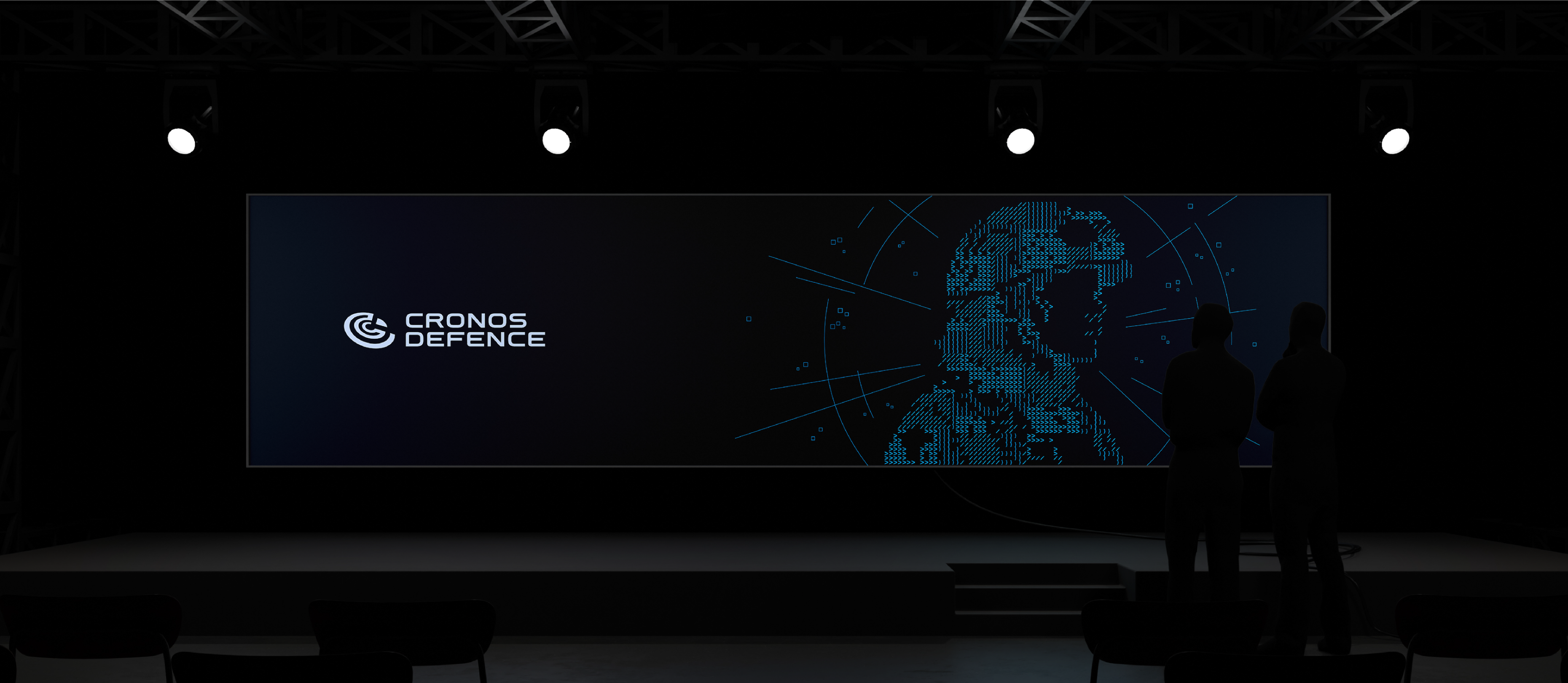 Dark conference stage with a large digital screen displaying the Cronos Defence logo and a stylized, pixelated profile of a soldier, while two silhouetted people stand in the foreground.