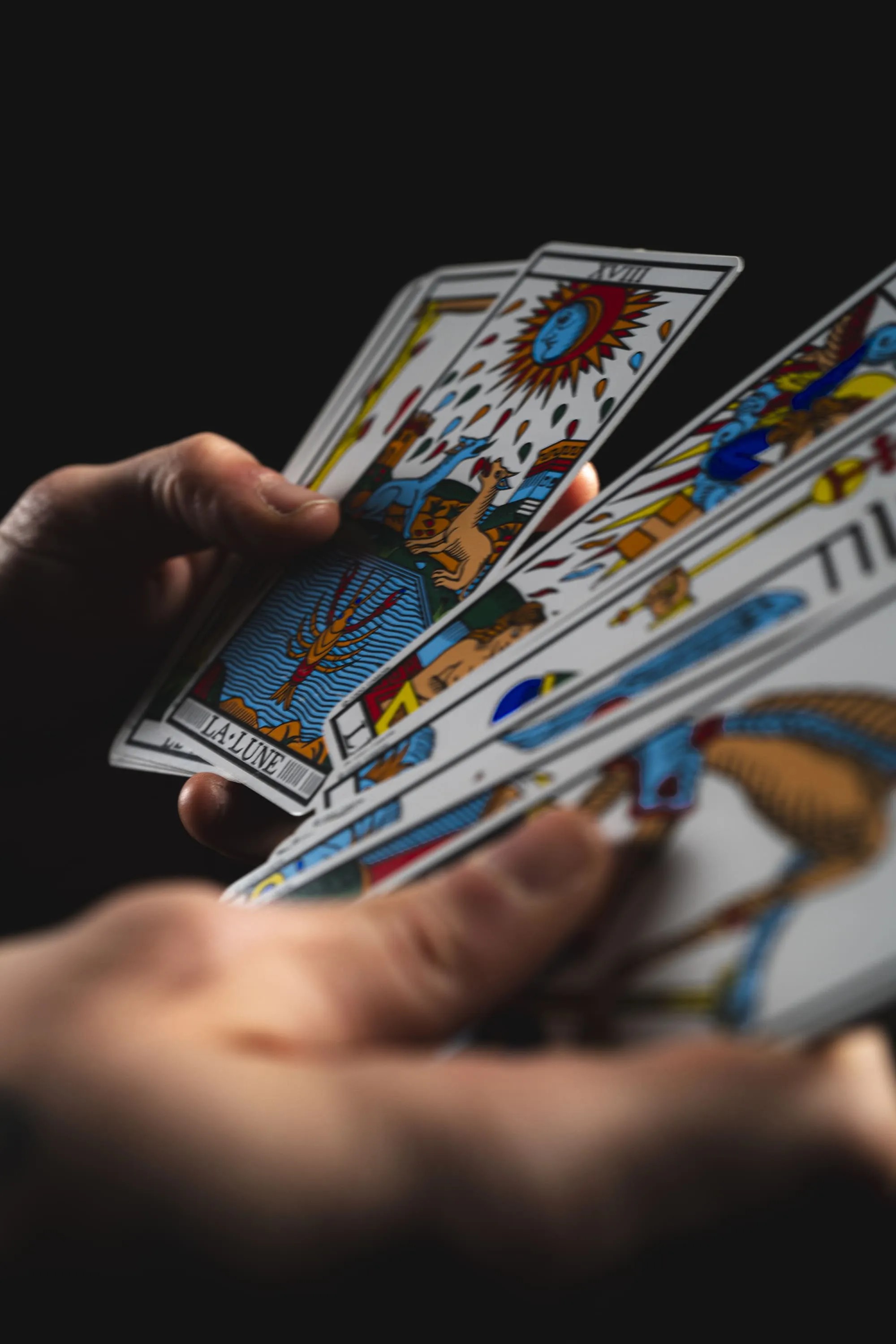 mains tenant des cartes de tarots